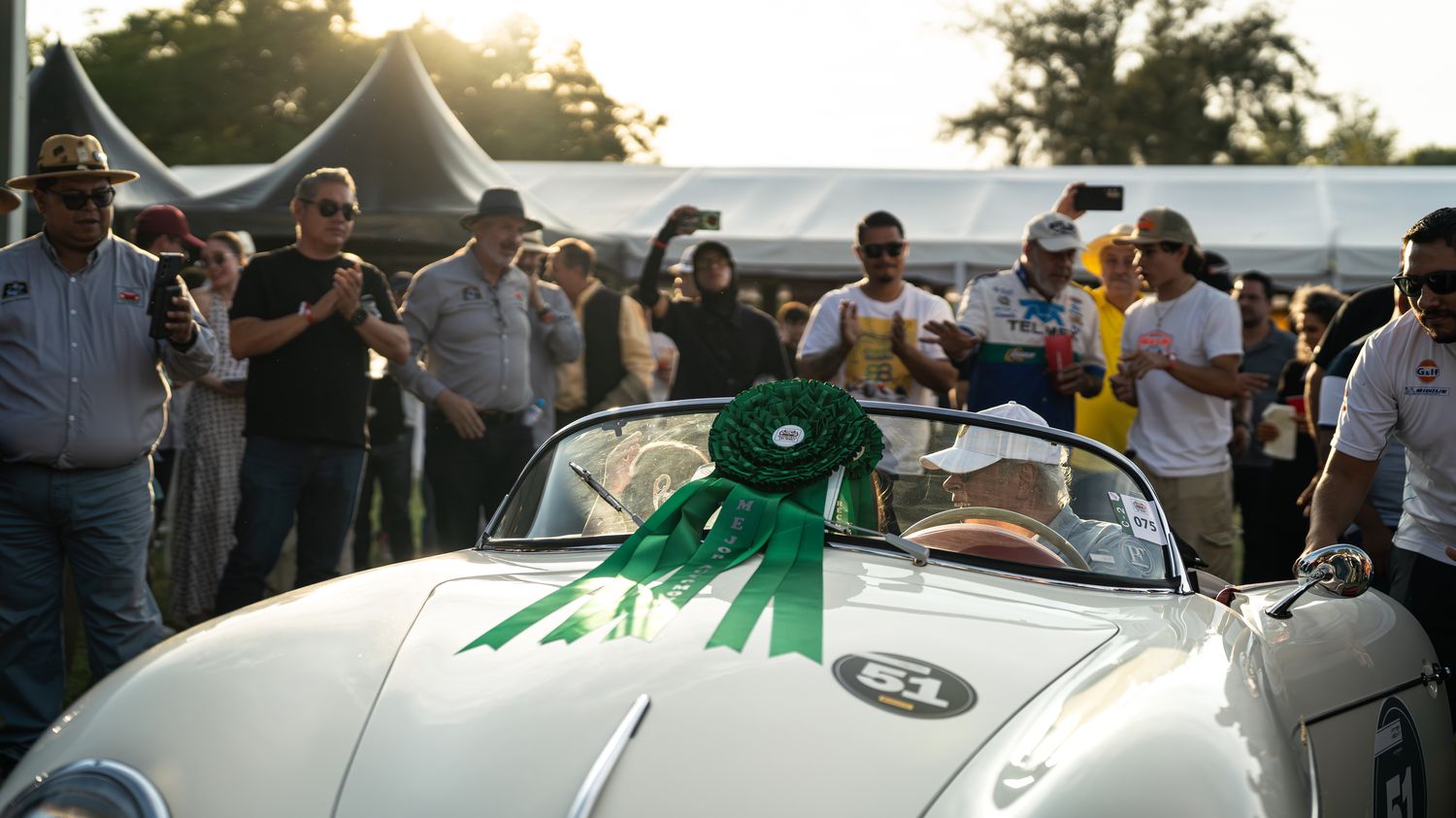 Participantes alrededor de un automóvil clásico en Gran Premio Histórico de la Ciudad de México